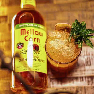 Glass of cocktail next to bottle