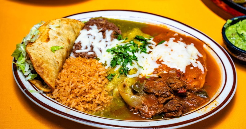 Mexican platter featuring rice enchiladas and braised meat