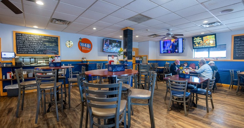 Casual bar and grill interior with high top tables and TVs