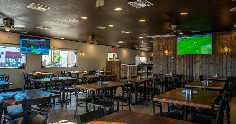 Interior, tables, chairs, windows, wall TVs, ceiling fans