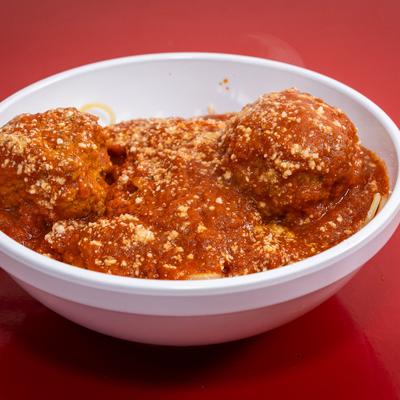 Spaghetti and meatballs in tomato sauce, topped with grated cheese.