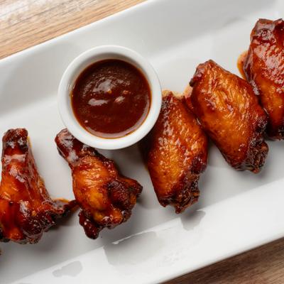 Barbecue chicken wings served with dipping sauce.
