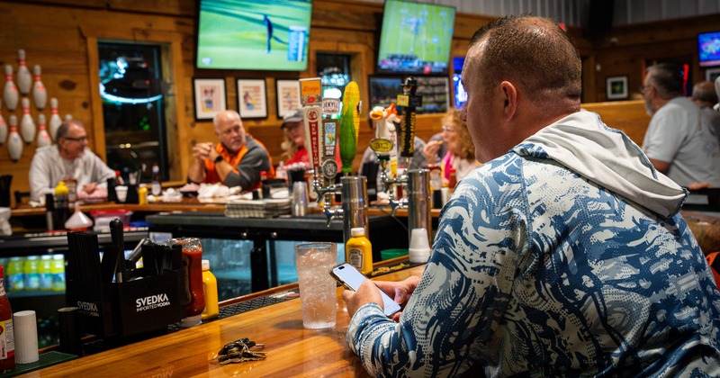 Bar area, people, tv's above