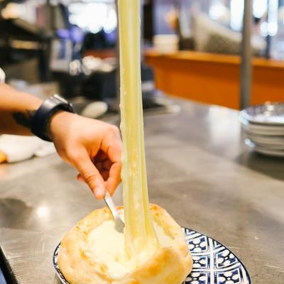 preparing ajaruli khachapuri - traditional georgian cheese bread with stretchy cheese