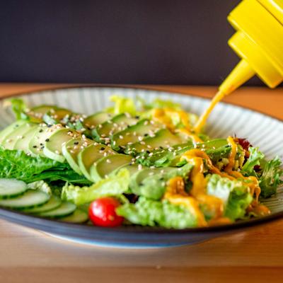 Sauce being drizzled over the Avocado Salad.