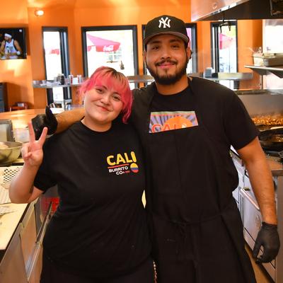 Two staffers posing for a picture in the kitchen setting.