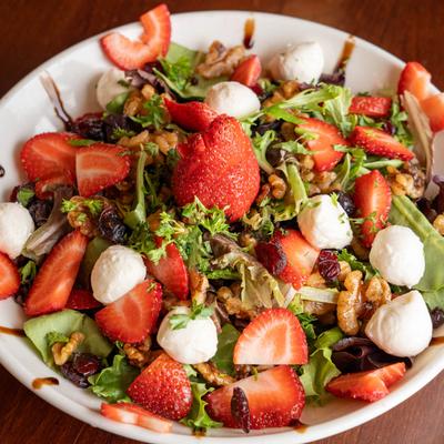 Strawberry salad with mozzarella, mixed greens, walnuts, and cranberries.
