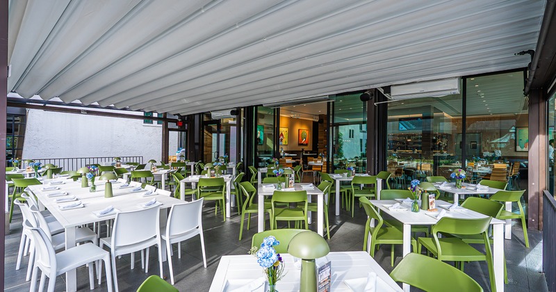 Spacious, modern and cozy enclosed patio with set dining tables