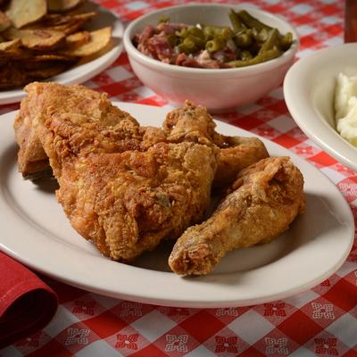 Pan fried chicken plate served on the table with sides.