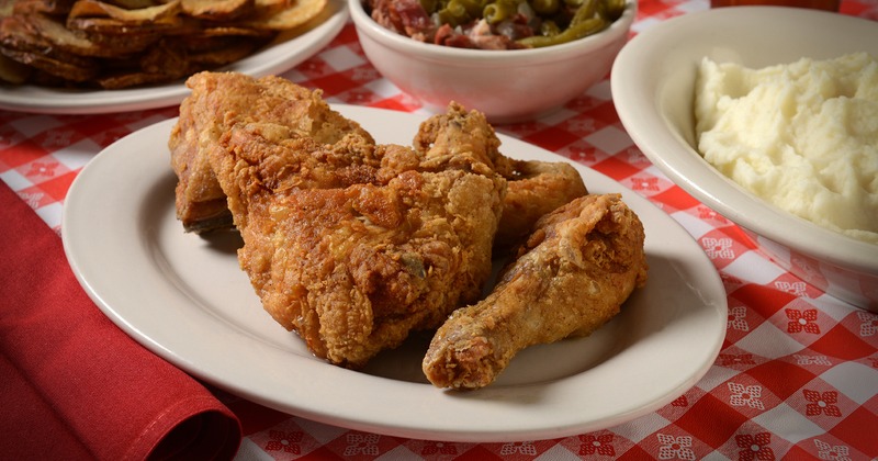 Pan fried chicken plate served on the table with sides