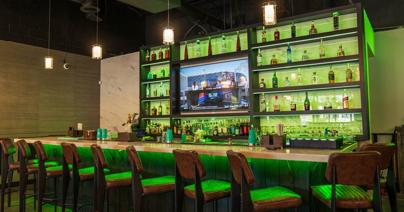 Interior, bar with bar stools, large over the wall drink shelf with TV in the middle