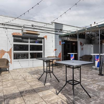 Outdoor patio with bar tables and seats.