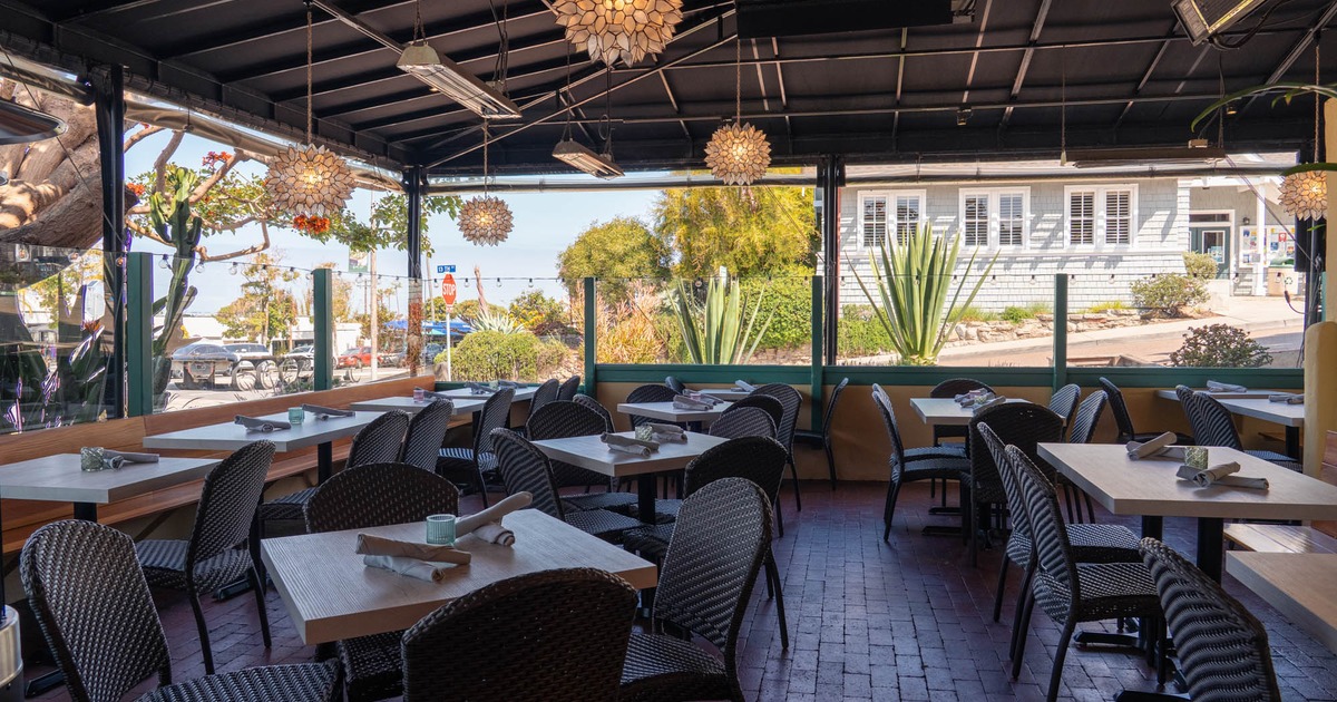 Covered patio featuring tables set with utensil roll-ups