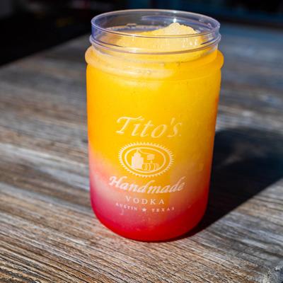 Frozen Tito's Vodka Lemonade with Mango and Strawberry flavors mixed in.