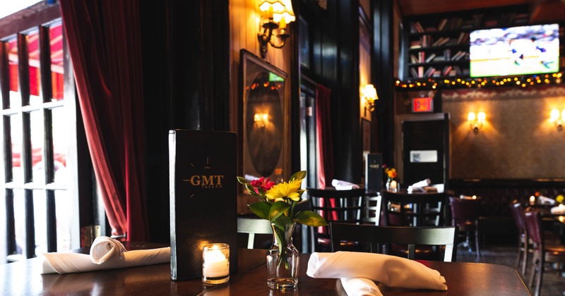 Interior, table closeup. GMT menu, candle light, flowers in a glass vase