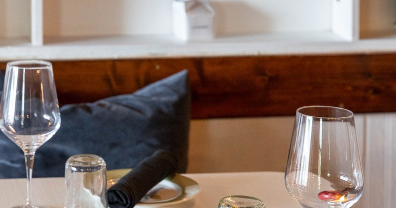 Table with empty wine and water glasses, plate and utensil roll-up