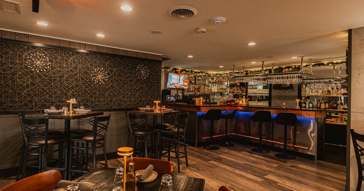 Interior, bar area, bar with stools, high seating tables for four, abstract wallpaper
