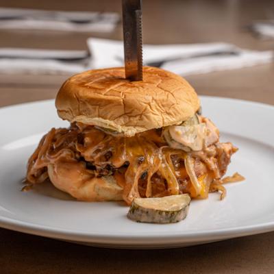 BBQ Pulled Pork Burger with pickles and grilled onions.