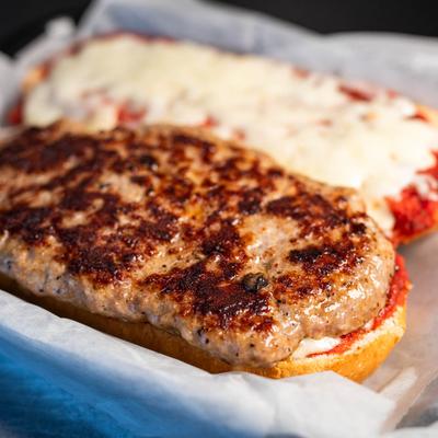 Pizza burger with a sausage patty, pizza sauce and mozzarella cheese.