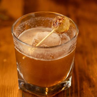 A cocktail garnished with a lollipop