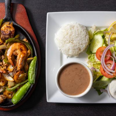 Chicken, shrimp, and steak Fajitas, with salad, rice, and beans.