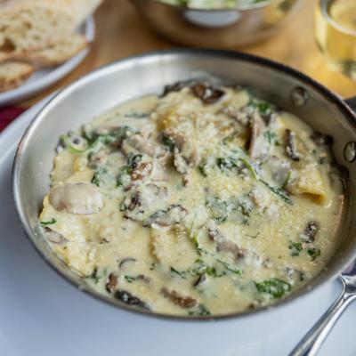 Wild Mushroom Ravioli served in a stainless steel skillet.