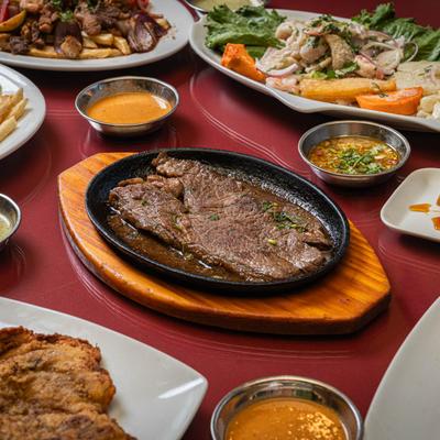 Bistec a Lo Pobre, surrounded by various dishes.