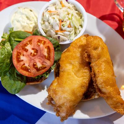 Battered fish with lettuce, tomato, onion, served with slaw and dip