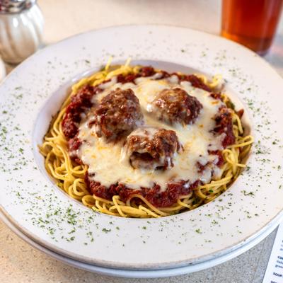 Spaghetti and meatballs with marinara sauce and melted cheese.