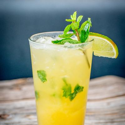Mango Pineapple Mojito, garnished with mint and lime.