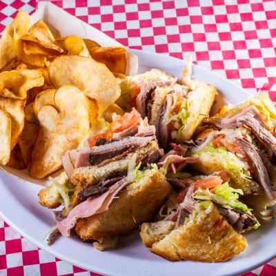 Club sandwiches and potato chips  served, top view