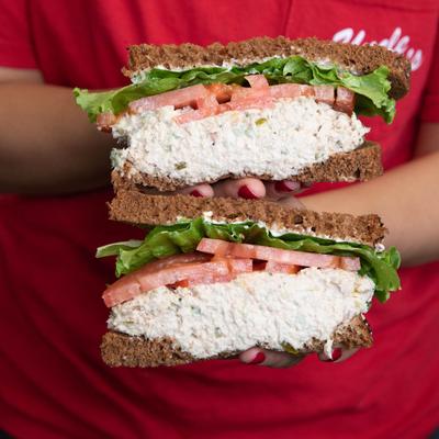 Attendant's hands holding a Canon Canon sandwich on display