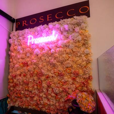 Restaurant neon sign on a flower wall.