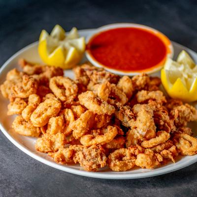 Fried calamari served with a side of marinara sauce and carved lemon.