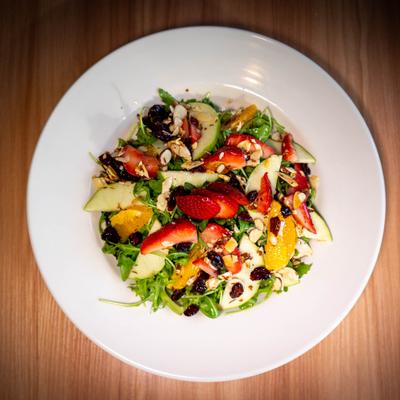 Mixed greens salad with strawberries, apples, and oranges.