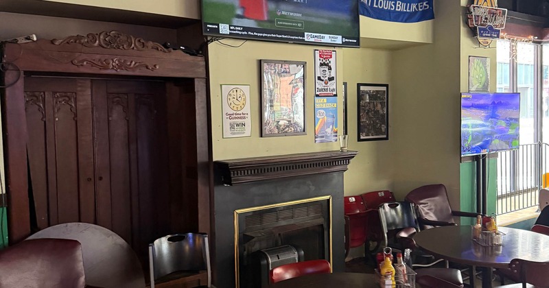 Interior - a TV, fireplace, university banners, various chairs and tables with condiments