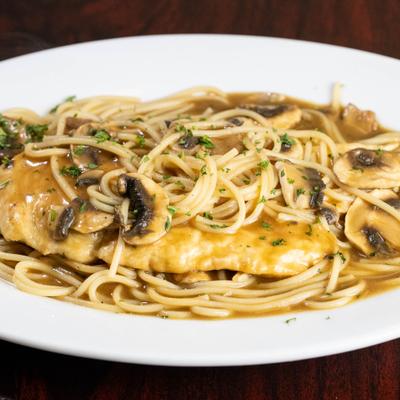 Chicken Marsala serwed with spaghetti in a mushroom sauce.