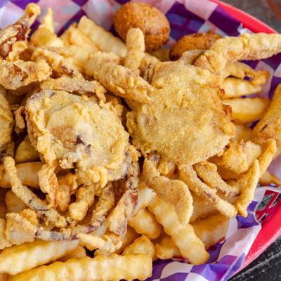 Fried Soft Shell Crab on a bed of french fries, close-up.