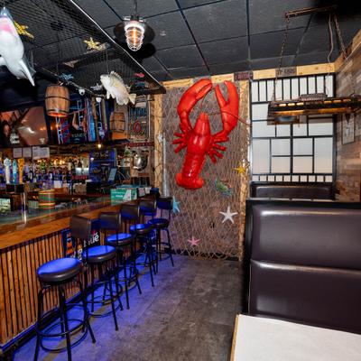 Bar area with stools, booth seating, and a large red lobster decoration.