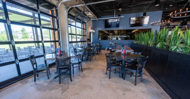 Interior, tables ready for guests, TVs on the wall