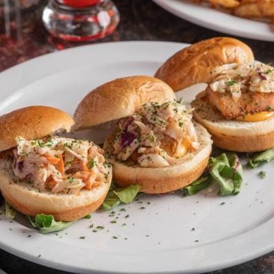 Salmon sliders on buns with coleslaw topping.