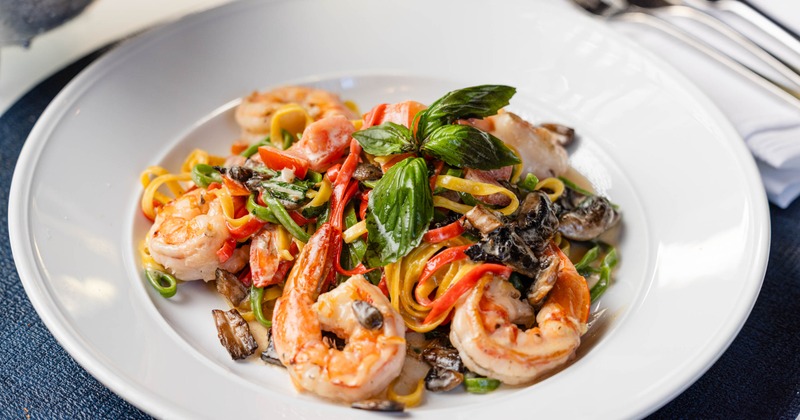 Plate of seafood pasta garnished with fresh basil