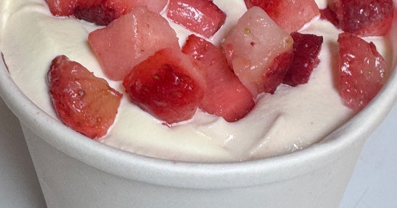Cup of yogurt topped with strawberry slices