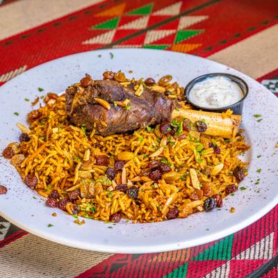 Lamb Shank Kabseh served with a dresssing.