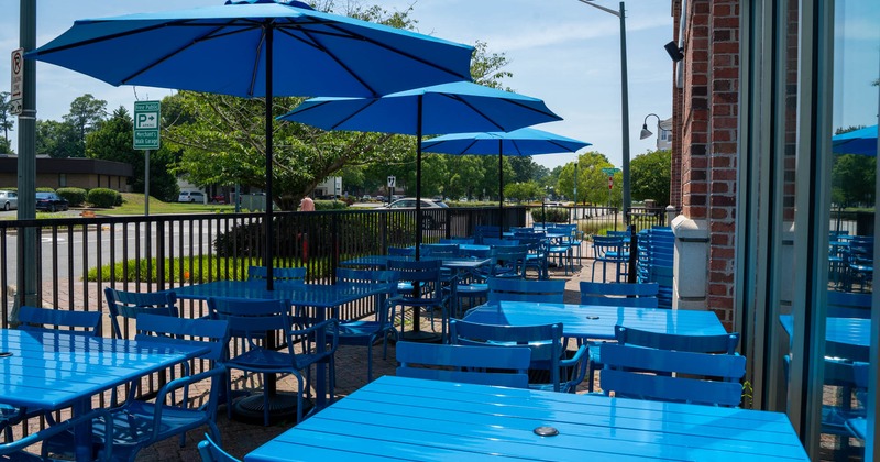 Exterior, front patio, partially covered seating area, tables and chairs under parasols