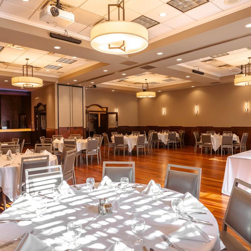 Banquet hall with set round tables and modern chandeliers