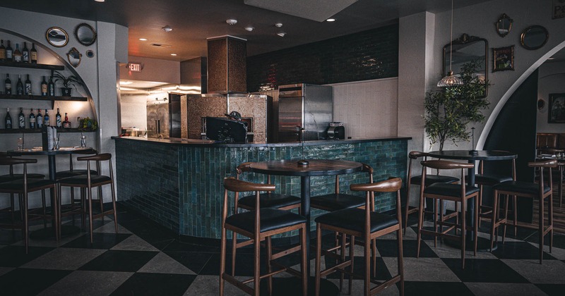 Bar and seating area with tall tables and bar stools