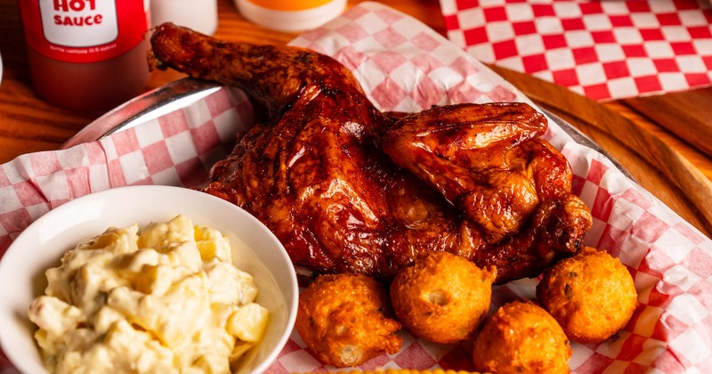 Half Chicken with hush puppies. corn on the cob, and potato salad