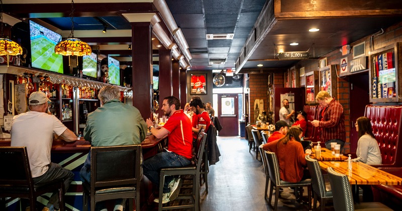 Interior, bar area, guests enjoying drinks, chatting and watching soccer matches