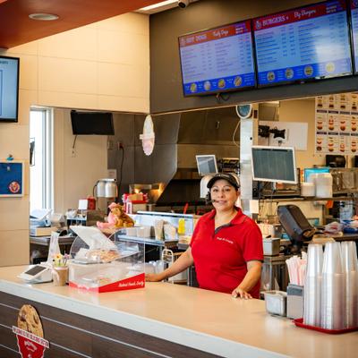 Interior, a friendly employee standing behind the counter.